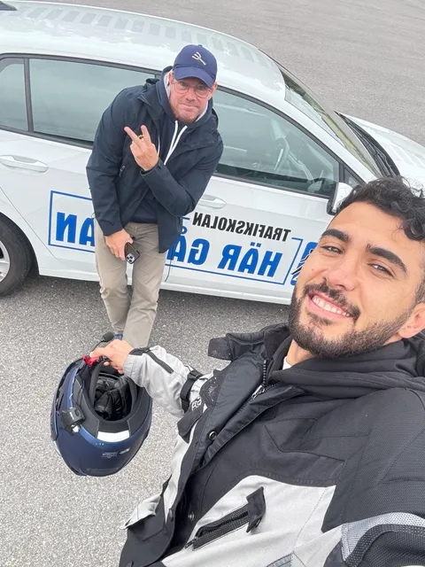 MC-elev med hjälm och instruktör framför övningsbilen