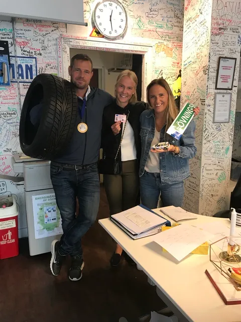Glad elev firar körkortet tillsammans med instruktörer från Trafikskolan Här Går Man