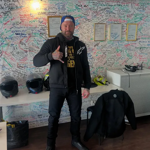 MC-elev gör shaka-tecken framför namnväggen