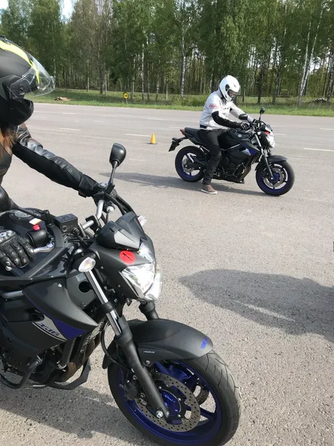 Två MC-elever under körlektion på övningsbanan