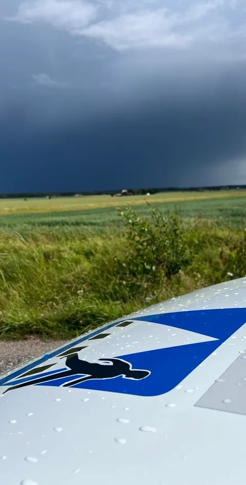 Trafikskolans logotyp på biltaket med dramatisk himmel i bakgrunden